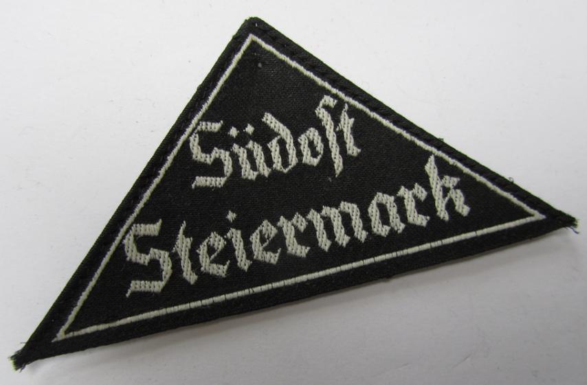 Attractive, 'HJ' ('Hitlerjugend') ie. 'BDM' ('Bund Deutscher Mädel'-) district-triangle (ie. 'Gebietsdreieck') entitled: 'Südost Steiermark' (being a 'virtually mint- ie. unissued' example that still retains its paper-based 'RzM'-etiket)