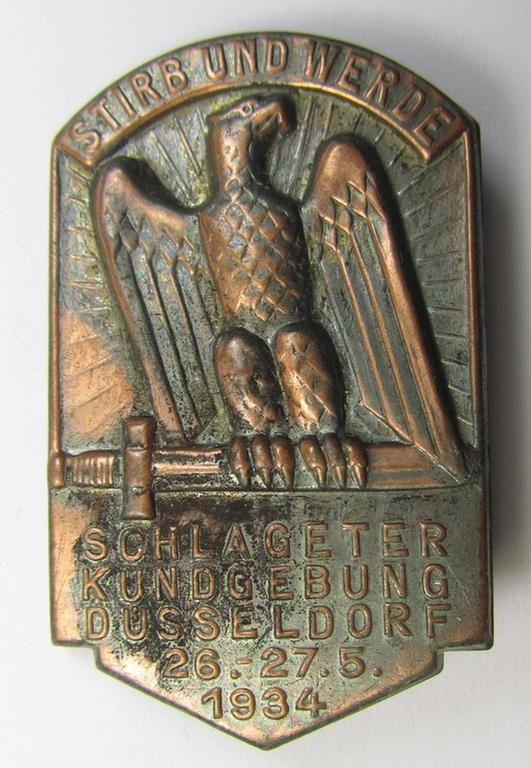 Commemorative, tin-based- and/or: golden-bronze-coloured (I deem) N.S.D.A.P.-related 'tinnie' depicting an eagle-device resting on a sword and that is entitled: 'Stirb und Werde - Schlageterkundgebung - Düsseldorf - 26.27.5.1934'
