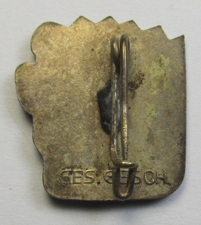 Attractive, silverish-coloured and 'Buntmetall'-based, N.S.D.A.P.-related lapel-pin (ie. 'Mitgliedsabzeichen') being a commemorative example that shows a sowing farmer-figure surrounded by an enamelled: 'Sunburst'-swastika