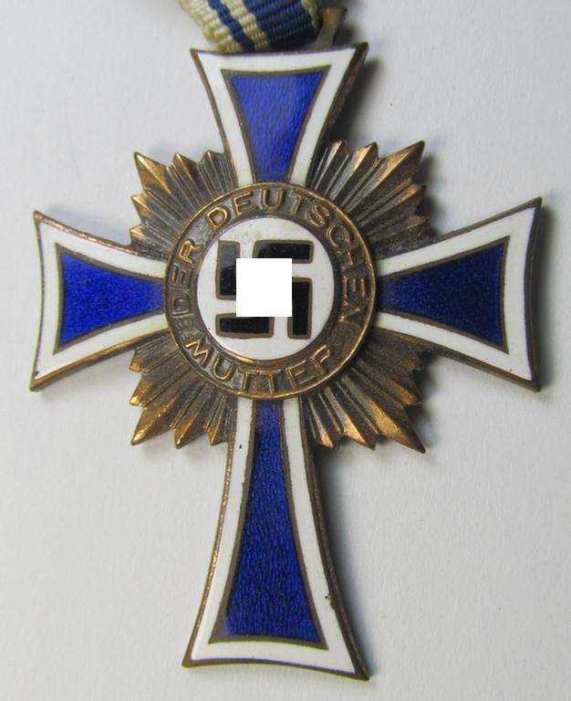 Attractive, 'Ehrenkreuz der deutschen Mutter - dritte Stufe' (or: bronze-class mothers'-cross) that came mounted onto its long-sized ribbon and that came stored in its period pouch (by the maker: 'Jakob Bengel - Idar-Oberstein')