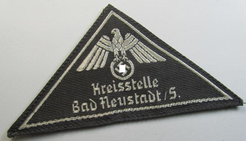 Attractive, German Red Cross (ie. 'Deutsches Rotes Kreuz' or 'DRK') greyish-coloured- and/or (typically) triangular-shaped arm-eagle entitled: 'Kreisstelle Bad Heustadt / S.' as was executed in the neat 'BeVo'-weave pattern