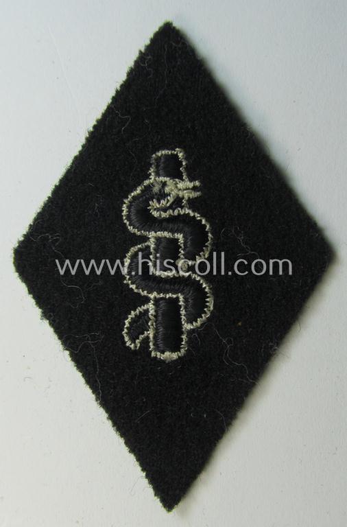 Waffen-SS-pattern, machine-embroidered and/or black- and white-coloured sleeve-insignia (ie. 'Ärmelraute') depicting a so-called: 'Aesculapus'-sign as was used and intended to signify membership within the 'SS-Sanitätsdienst'