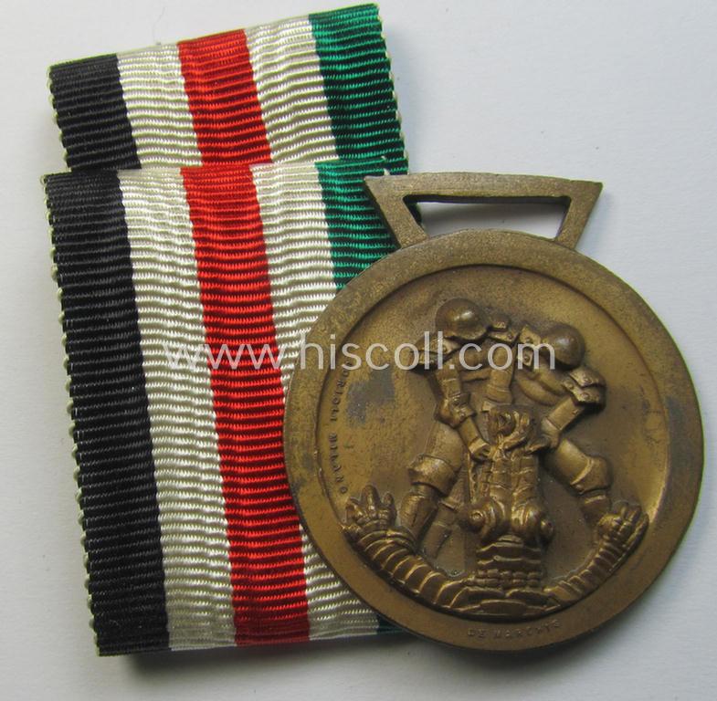 Superb, golden-bronze-coloured- (and I deem 'Buntmetall'-based-) example of a: 'Deutsch-Italienische Feldzugsmedaille' (or: German-Italian campaign medal) that came together with its (regular-sized) piece of original ribbon