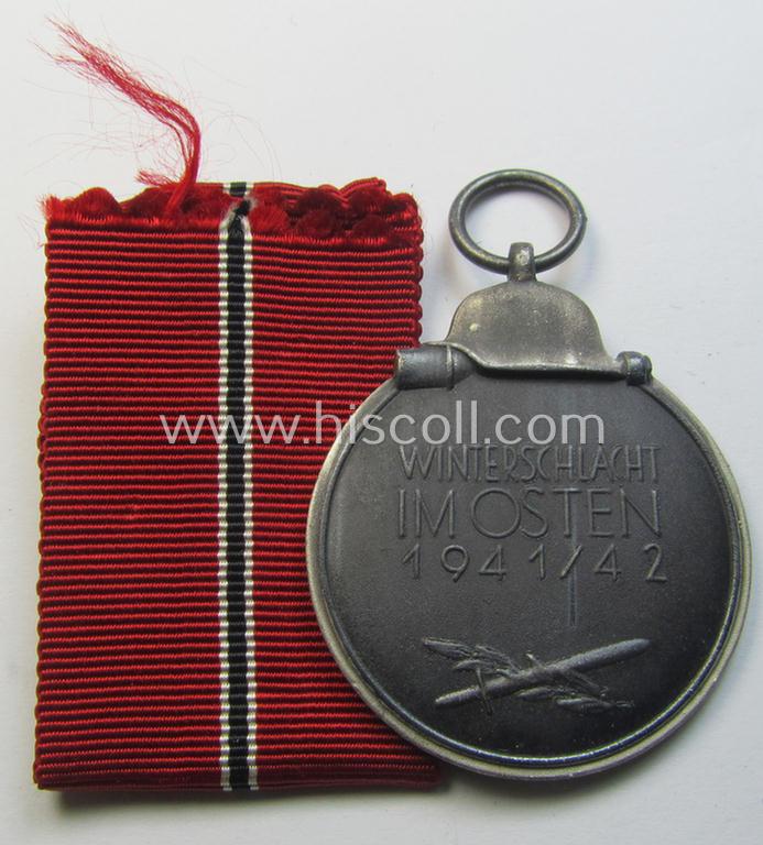 Attractive medal-set: 'Winterschlacht im Osten 1941-42' being a maker- (ie. '127'-) marked- (and/or 'Feinzink'-based) specimen by the maker: 'Moritz Hausch A.G.' and that comes together with its (non-confectioned) ribbon (ie. 'Bandabschnitt')