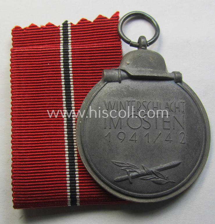 Attractive medal-set: 'Winterschlacht im Osten 1941-42' being a maker- (ie. '61'-) marked- (and/or 'Feinzink'-based) specimen by the maker: 'R.A. Karneth & Söhne' and that comes together with its (non-confectioned) ribbon (ie. 'Bandabschnitt')