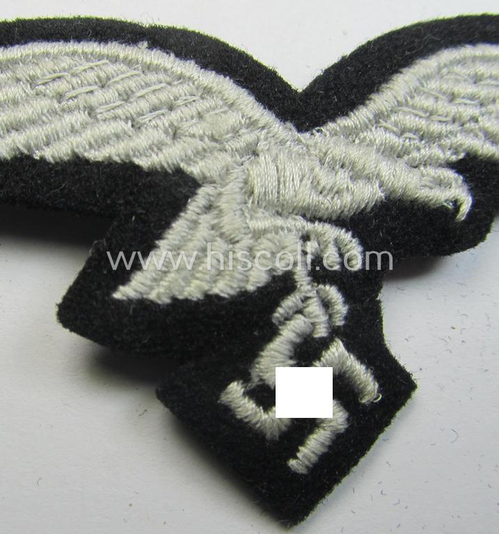 Attractive, WH (Luftwaffe) cap-eagle (being a 'standard-issue'-pattern example as executed onto a black-coloured and woolen-based background and as such intended for usage on the black-coloured work- ie. 'HG'-related side-caps ie. 'Schiffchen')