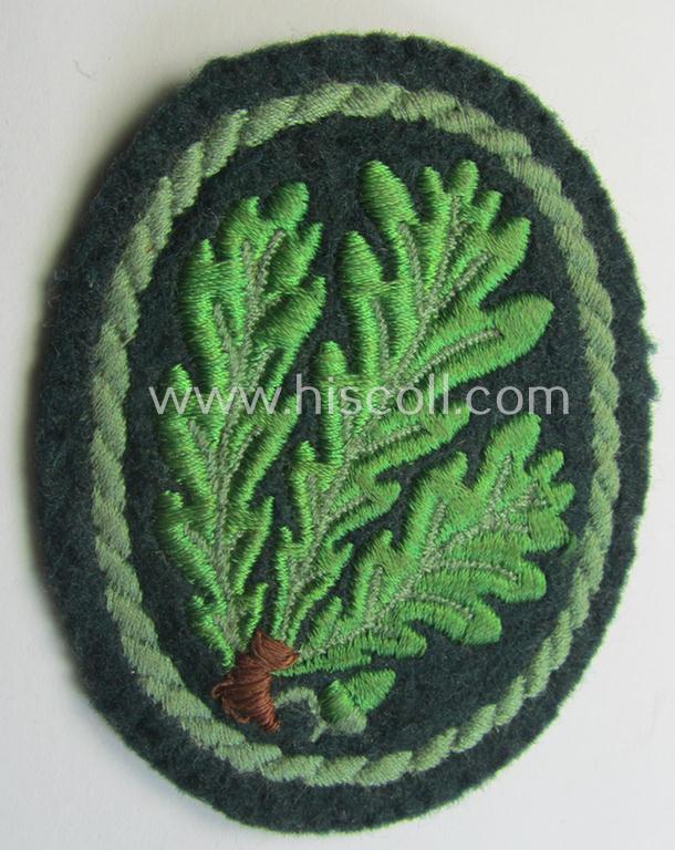 Attractive example of a WH (Heeres) so-called: 'Jäger'-armbadge being a neatly machine-embroidered- and/or multi-coloured version as was executed on darker-green-coloured wool
