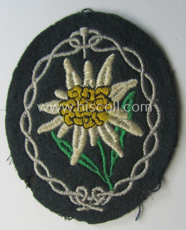 Truly used and/or tunic-removed, WH (Heeres) EM- (ie. NCO-) type, so-called: 'Edelweiss'-armpatch being a machine-embroidered example as was executed on darker-green wool as was specifically intended for usage by the: 'Gebirgsjäger-Truppen'