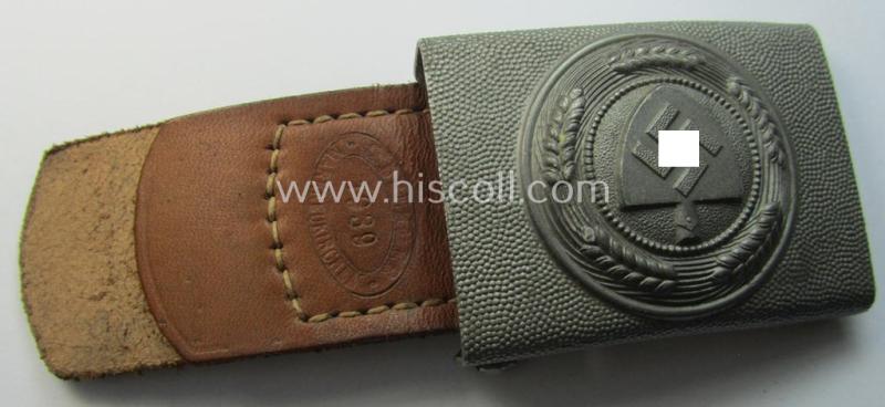 Silverish-grey-toned, 'Reichsarbeitsdienst'- (ie. RAD-) enlisted-mens'- (ie. NCO-) type belt-buckle being a maker- (ie. 'Gustav Brehmer'-) marked example which is dated: '1939' and that comes mounted onto its leather-based tab