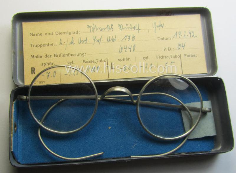 Complete pair of 'standard-issued'-pattern, WH-service-glasses (ie. 'Dienstbrille') as issued to the: 'Gefr. Andreas Rüdolf' (or alike) serving within the: '2./L.Art.Ers.Abt. 176' and that comes stored in its period-container