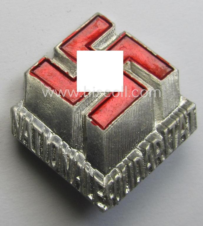 Silverish-coloured and aluminium-based, N.S.D.A.P.-related lapel-pin (ie. 'Mitgliedsabzeichen') being a commemorative example that shows an (enamelled and three-dimensional!) swastika surrounded by the text: 'Nationale Solidarität'