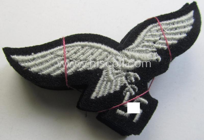 WH (Luftwaffe) cap-eagle (being a 'standard-issue'-pattern example that is executed onto a black-coloured background and that was as such intended for usage on the black-coloured work- ie. 'HG'-related side-caps ie. 'Schiffchen')