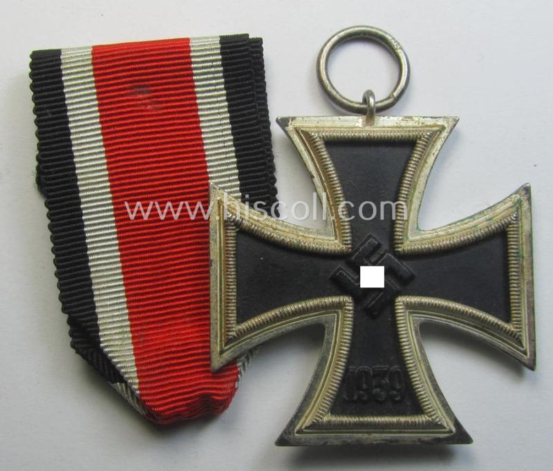 'Eisernes Kreuz II. Klasse' being a maker- (ie. '113'-) marked example that comes together with its original- (and once-mounted) ribbon (ie. 'Bandabschnitt') by the maker (ie. 'Hersteller'): 'Hermann Aurich'