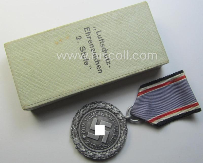 Light-weight (ie. typical aluminium-based) medal as was intended for air-raid wardens 2nd. class (or: 'Luftschutz-Ehrenzeichen 2. Stufe') that comes stored in its period, dove-grey-coloured etui