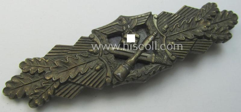 'Nahkampfspange in Bronze' (or: bronze-class close-combat clasp ie. CCC) being a maker- (ie. 'A.G.M.u.K.'-) marked- and/or minimal converse-shaped specimen having its period-attached (bluish-toned and steel-based) 'back-plate' in place