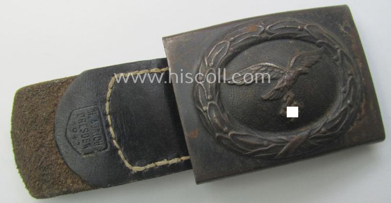 WH (Luftwaffe) bluish-grey-coloured, steel-based belt-buckle being a maker- (ie. 'H. Aurich'-) marked- and/or: '1942'-dated example that comes mounted onto its leather-based tab