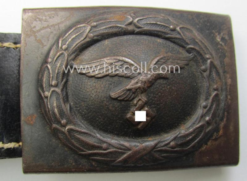 WH (Luftwaffe) bluish-grey-coloured, steel-based belt-buckle being a maker- (ie. 'H. Aurich'-) marked- and/or: '1942'-dated example that comes mounted onto its leather-based tab