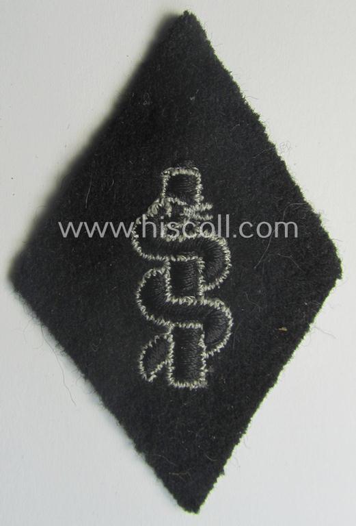Waffen-SS-pattern, machine-embroidered and/or black- and white-coloured sleeve-insignia (ie. 'Ärmelraute') depicting a so-called: 'Aesculapus'-sign as was used and intended to signify membership within the 'SS-Sanitätsdienst'