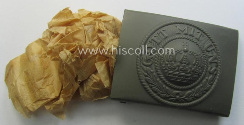 WWI-period field-grey-coloured- and/or steel-based belt-buckle being a (typical) non-maker-marked example that shows the motto: 'Gott mit Uns' and came still packed into its period piece of thin-shaped 'wrapping-paper'