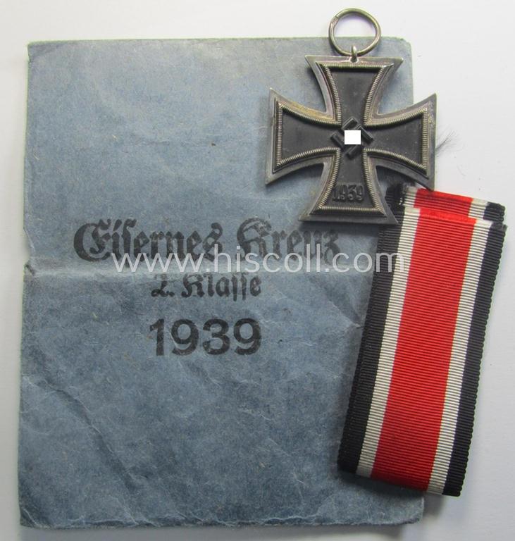 'Eisernes Kreuz 2. Kl.' being a maker- (ie. '76'-) marked example that comes stored in its period 'Zellstoff'-based pouch by the: 'Ernst L. Müller'-company as was based in the town of Pforzheim