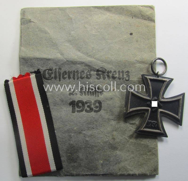 'Eisernes Kreuz 2. Kl.' being a maker- (ie. '55'-) marked example that comes stored in its period 'Zellstoff'-based pouch by the: 'J.E. Hammer & Söhne'-company as was based in the town of Geringswalde