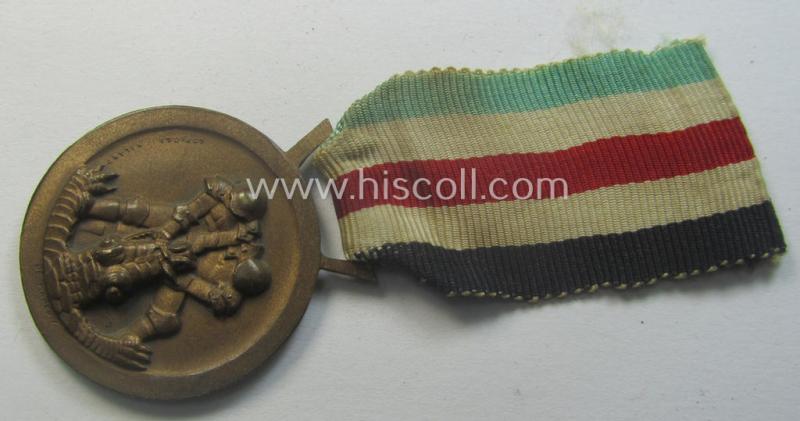 Golden-bronze-coloured example of a: 'Deutsch-Italienische Feldzugsmedaille' (or: German-Italian campaign-medal) that comes mounted onto its (regular-sized) piece of original (and minimally faded- ie. stained!) ribbon