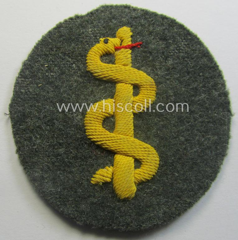 WH (Heeres) so-called: trade- and/or special-career arm-insignia as was intended for a: 'Sanitäter' being a neatly hand-embroidered specimen on a field-grey-coloured background