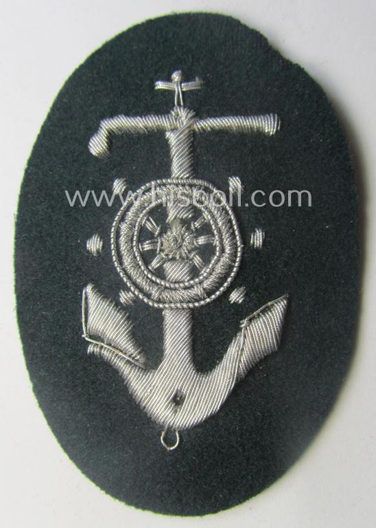 WH (Heeres) trade- and/or special-career insignia being a detailed- and/or neatly hand-embroidered example as executed on darker-green-coloured wool as was intended for a: 'Steuermann' (ie. enigineer-boat-pilot or helmsman)