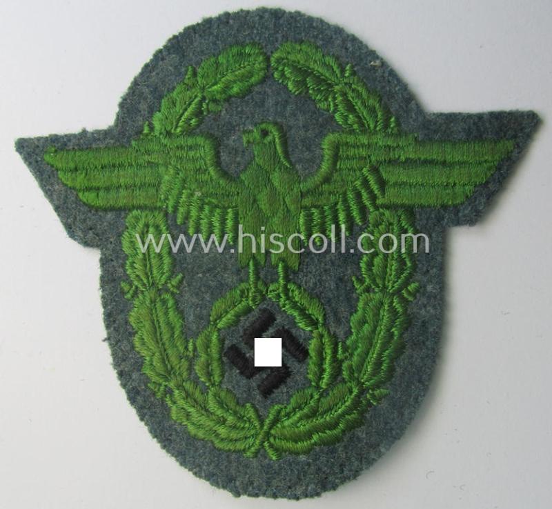 Clearly used- and/or tunic-removed, police- (ie. 'Polizei'- ie. 'Gendarmerie'-) related machine-embroidered-pattern arm-eagle, as executed in bright-green-coloured linnen on a typical 'Polizei'-coloured- and/or woolen-based, background