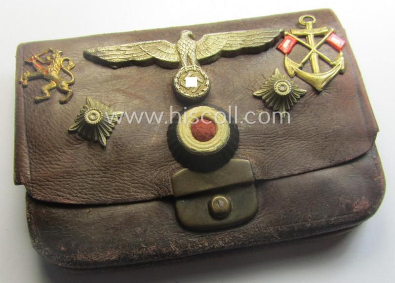 Unusual, WH (Kriegsmarine) item that comes as a 'period-souvenir': a leather-based 'wallet' that holds various Kriegsmarine-insignia (such as a visor-cap-eagle, cocarde, 2 pips, signals-'Auflage' and an (unidentified) 'Lion'-badge
