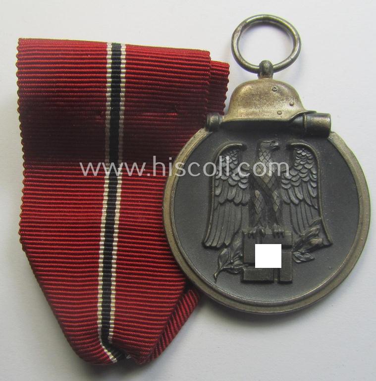 Medal-set: 'Winterschlacht im Osten 1941-42' being a maker- (ie. '93'-) marked- (and/or 'Feinzink'-based) specimen by the maker: 'Richard Simm & Söhne' and that comes together with its (minimally confectioned) ribbon (ie. 'Bandabschnitt')