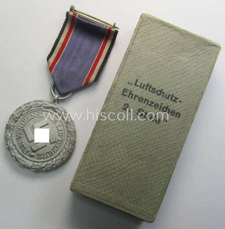 Light-weight (ie. typical aluminium-based) medal as was intended for air-raid wardens 2nd. class (or: 'Luftschutz-Ehrenzeichen 2. Stufe') that comes stored in its period, dove-grey-coloured etui