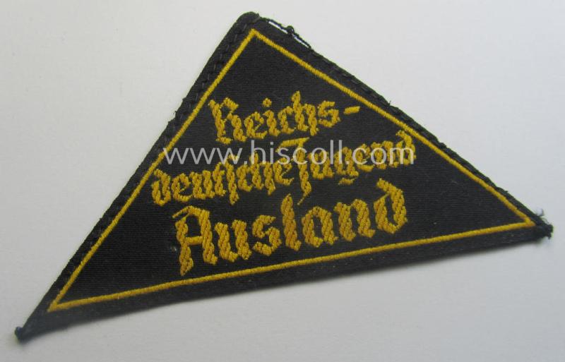 'HJ' ('Hitlerjugend') district-triangle (ie. 'Gebietsdreieck') entitled: 'Reichs-deutsche Jugend Ausland' being an (I deem) minimally worn- ie. used specimen that retains its 'RzM'-etiket