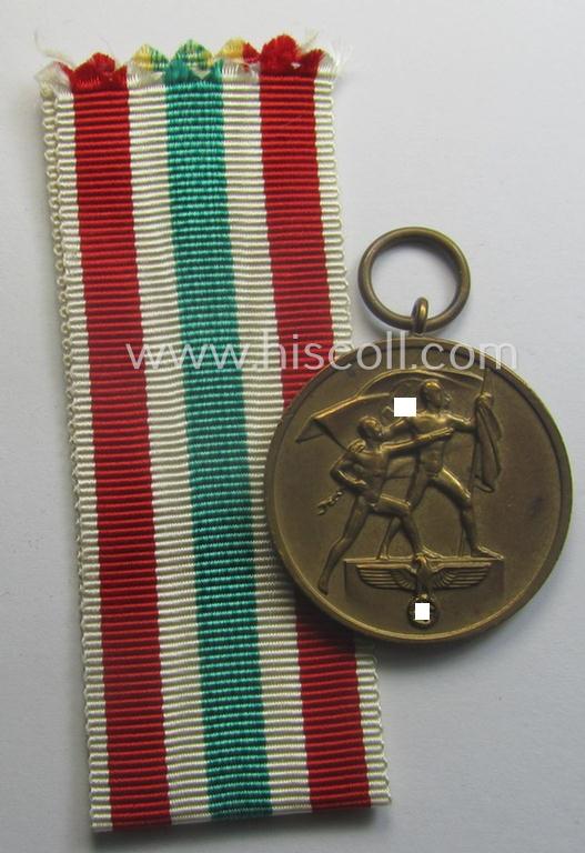 WH Memelland 'Anschluss'- (ie. occupation-) medal: '22 März 1939' (being a minimally used example of the so-called: 'slanted G'-type) that comes together with its original non-confectioned ribbon (ie. 'Bandabschnitt')