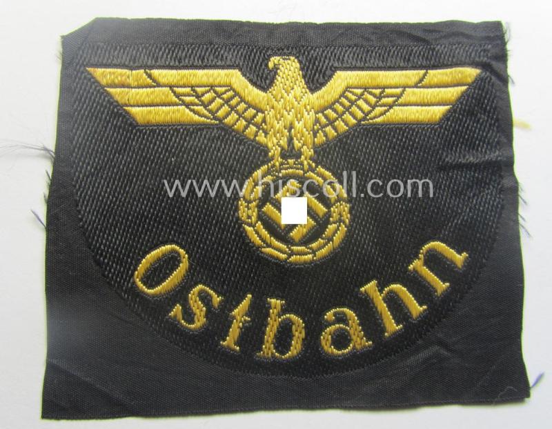 RB- ('Reichsbahn'-) related arm-eagle (ie. 'Ärmeladler') depicting the text: 'Ostbahn' (as was presumably intended for an official of the: 'Deutsche Reichsbahn' ie. the: 'WVD im Osten' ie.: 'Wehrmacht-Verkehrsdirektion im Osten')