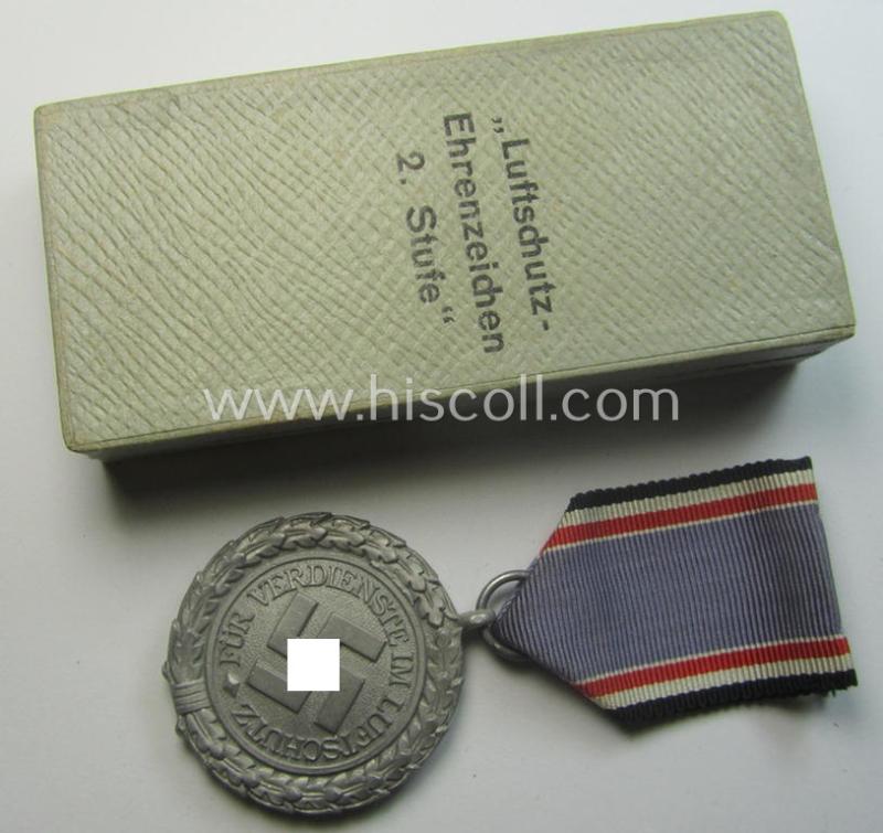 Light-weight (ie. typical aluminium-based) medal as was intended for air-raid wardens 2nd. class (or: 'Luftschutz-Ehrenzeichen 2. Stufe') that comes stored in its period, dove-grey-coloured etui