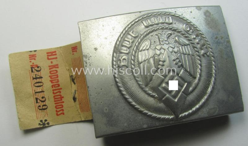 HJ ('Hitlerjugend'), zinc-based belt-buckle being a 'virtually mint' and/or non-maker-marked example having a seldomly seen 'cranked-catch'-set-up and that comes with its period 'RzM'-etiket still attached