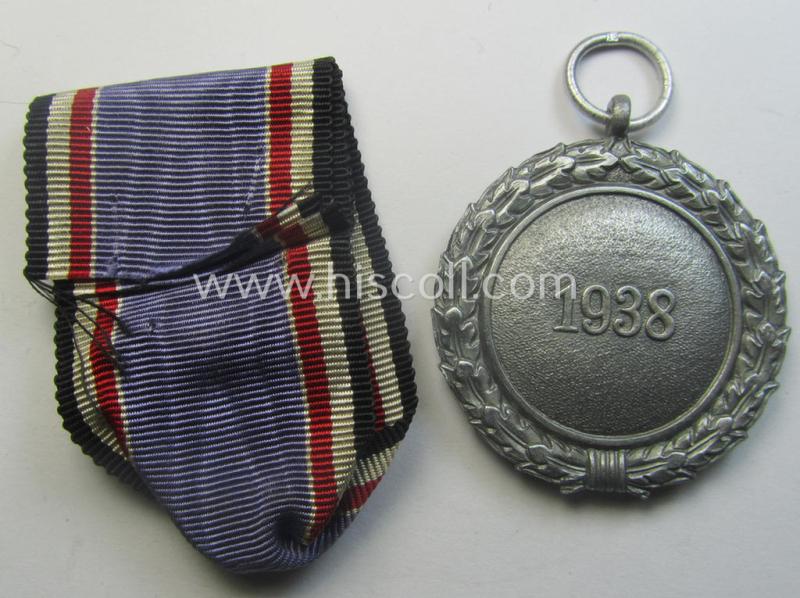 'Luftschutz-Ehrenzeichen 2. Stufe' being a maker- (ie. '10'-) marked example, as executed in (heavy) zinc-based metal (ie. 'Feinzink') and that came together with its period ribbon (ie. 'Bandabschnitt')