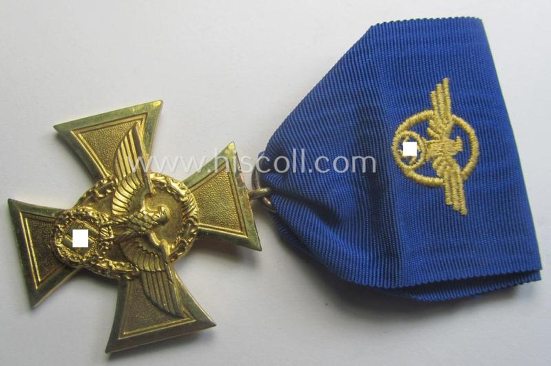 Golden-class 'Pol.-Dienstauszeichnung 1. Stufe' (or: police loyal-service medal first-class) that comes mounted onto its (typically broader-shaped) ribbon (ie. 'Bandabschnitt')