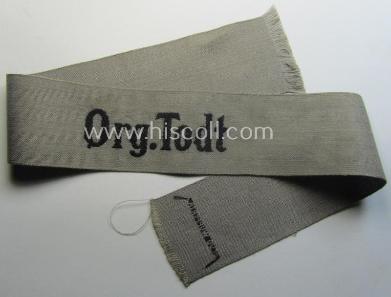 OT (ie.: 'Organisation Todt') greyish-coloured, enlisted-mens'- (ie. NCO-) pattern cuff-title (ie. 'Ärmelstreifen für Mannschaften u. Unteroffiziere') being a moderately used- ie. tunic-removed example depicting the text: 'Org.Todt'
