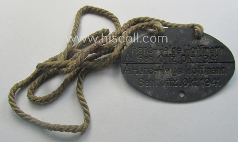 Interesting, early-war- (albeit 'standard-issue'-) pattern, WH (Kriegsmarine) typical zinc-based- and/or greyish-silver toned ID-disc (ie. 'Erkennungsmarke') bearing the engraved text that simply reads: 'Hans-Helge Hoffmann - San.Offz. Okt. 1941'