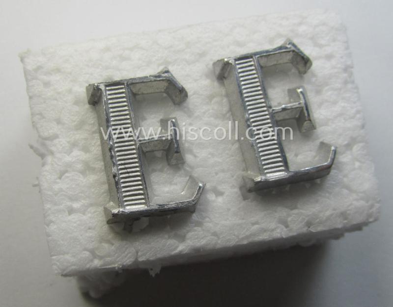 Pair of NCO-type- (thus silver-coloured), Waffen-SS- (ie. SS-VT-) related shoulderstrap-cyphers (ie. 'Schulterstückauflagen o. Ziffern') depicting a capital 'E'-character for usage by an NCO serving within the: 'Ergänzungsstellen der Waffen-SS'