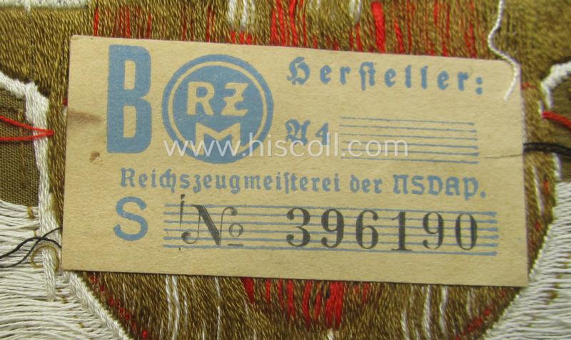 Rarely encountered - and 'virtually mint- ie. unissued' - breast-badge as executed in 'BeVo-weave' pattern as was intended for members within the 'N.S.D.A.P. Reichsautozug' (or: 'RaZ') still retaining its period, paper-based 'RzM'-etiket