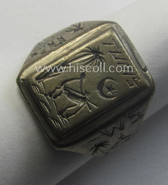 WH (LW-/Heeres- ie. 'Deutsches Afrikakorps'-) related, metal-based (ie. silver-coloured- and/or I deem genuine silver-based) so-called: 'souvenir'-ring depicting an engraved palmtree and desert scenery and showing the text: 'Tunis'