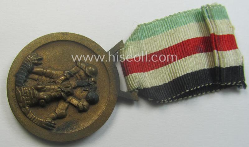 Golden-bronze-coloured- (and I deem 'Buntmetall'-based-) example of a: 'Deutsch-Italienische Feldzugsmedaille' (or: German-Italian campaign-medal) that comes mounted onto its (regular-sized) piece of original (and minimally faded!) ribbon