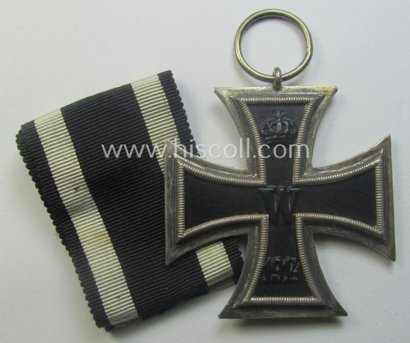 WWI-period: 'Eisernes Kreuz II. Klasse' (or: iron cross second class) being a maker- (ie. 'KO'-) marked example that comes together with its (minimally) confectioned piece of ribbon (ie. 'Bandabschnitt')