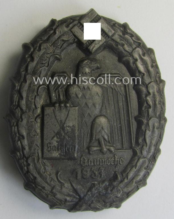 Greyish-silver-coloured- and (unusually!) 'molded'-aluminium-based, N.S.D.A.P.-related day-badge (ie. 'tinnie' or: 'Veranstaltungsabzeichen') bearing the text: 'Gauwoche Sachsen 1937' (being a maker- ie. 'K. Würster'-marked example)