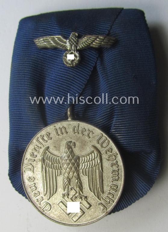 Bright-silver-toned WH (Heeres o. KM) so-called: 'Einzelspange' showing a: 'WH-Dienstauszeichnung 4. Stufe' (as was intended for 4 years of loyal-service) and that shows a detailed, Heeres o. KM-type-eagle-device, period-attached