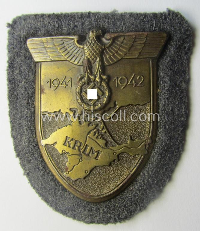 WH (Luftwaffe) 'Krim'-campaign-shield that comes mounted onto its original, bluish-grey-coloured 'backing' and that comes in a surely issued-, minimally worn and/or (I deem) carefully tunic-removed-, condition