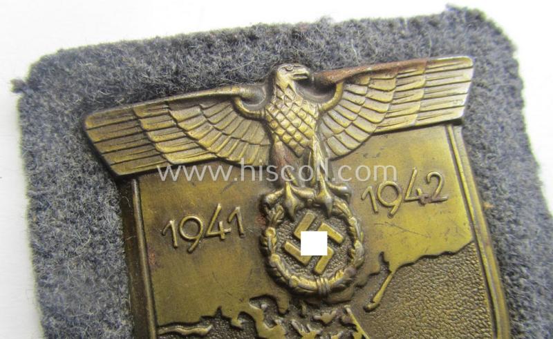 WH (Luftwaffe) 'Krim'-campaign-shield that comes mounted onto its original, bluish-grey-coloured 'backing' and that comes in a surely issued-, minimally worn and/or (I deem) carefully tunic-removed-, condition